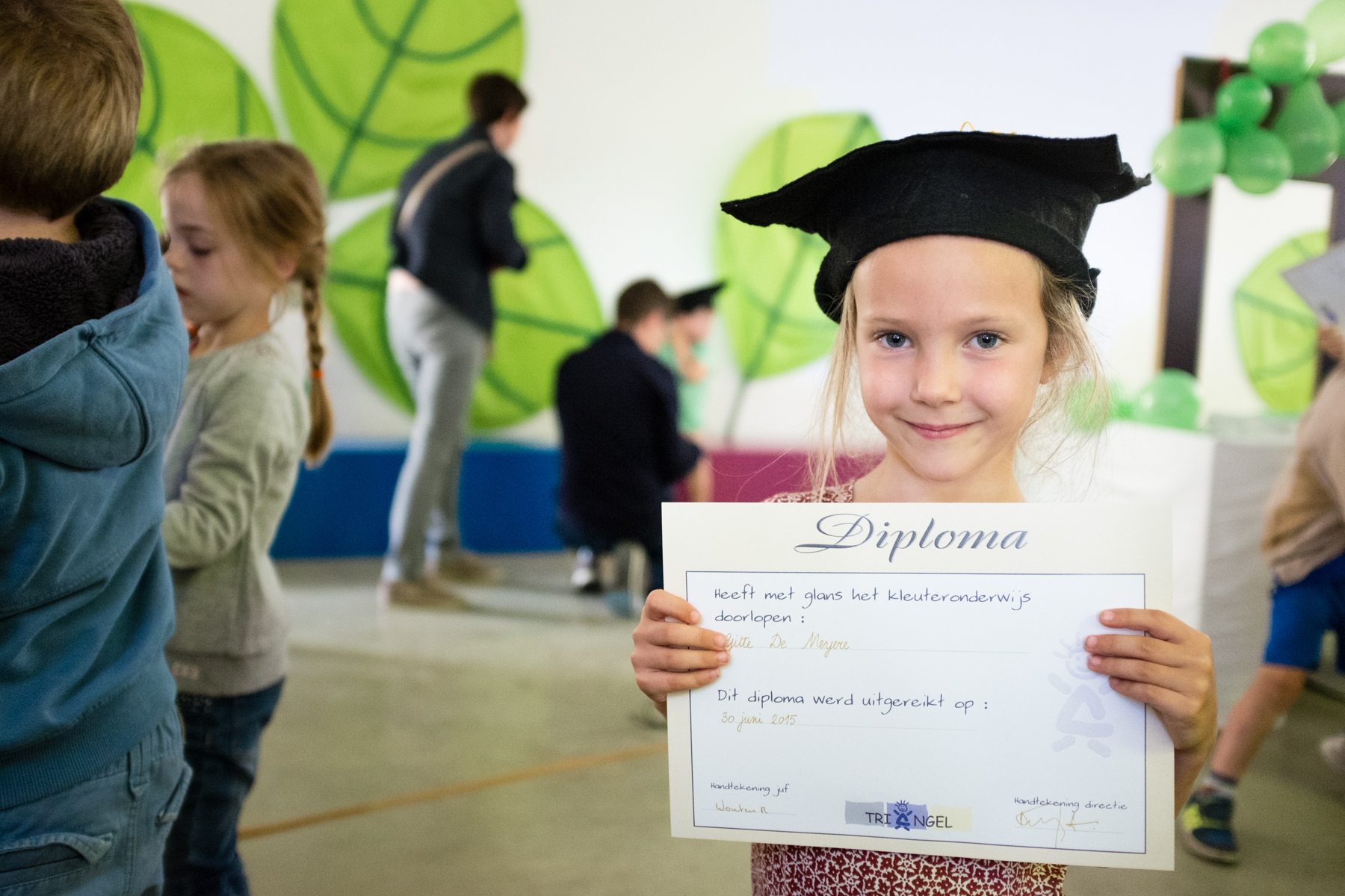 Gitte toont fier haar diploma.